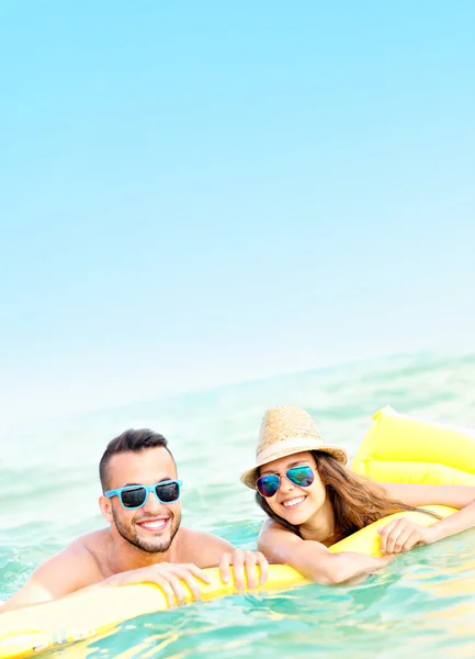 Pareja joven divirtiéndose en el mar — Foto de Stock