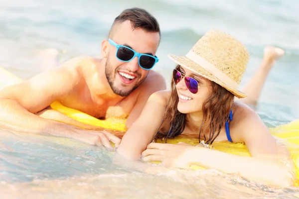 Young couple swimming on a matress — Stock Photo, Image