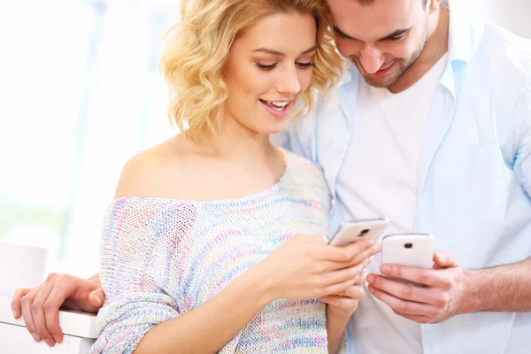 Pareja feliz usando teléfono inteligente — Foto de Stock