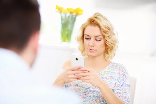 Jonge vrouw texting thuis — Stockfoto