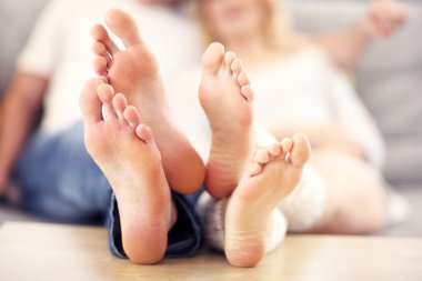 Barefeet of a happy couple lying on a sofa clipart
