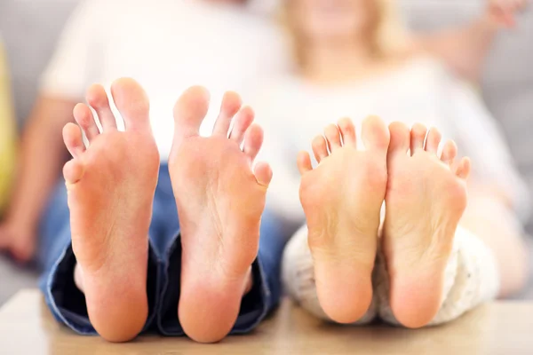 Descalços de um casal feliz deitado em um sofá — Fotografia de Stock