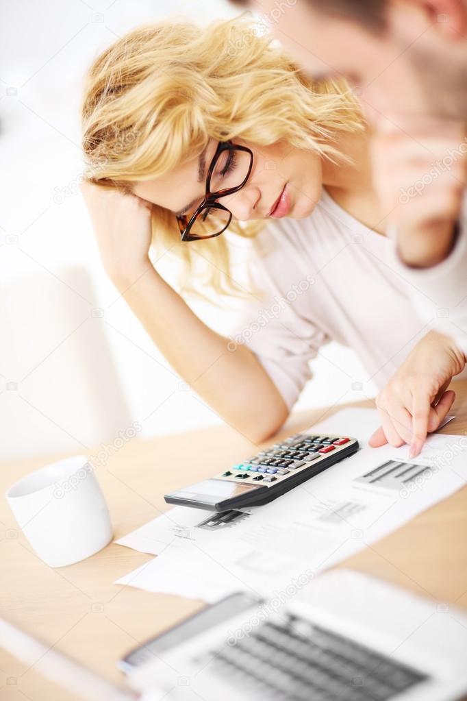 Unhappy couple with documents at home