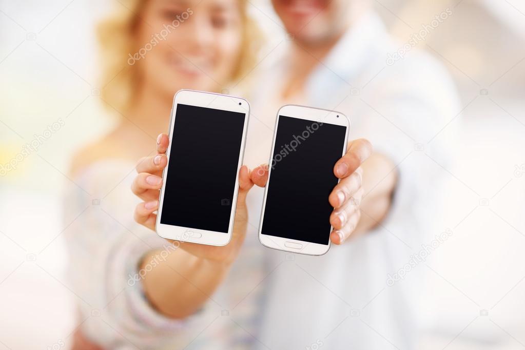 Couple showing their smartphones