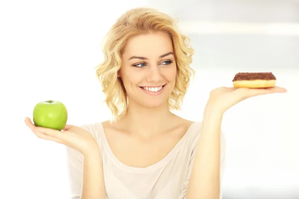 Счастливая женщина с пончиком и яблоком — стоковое фото