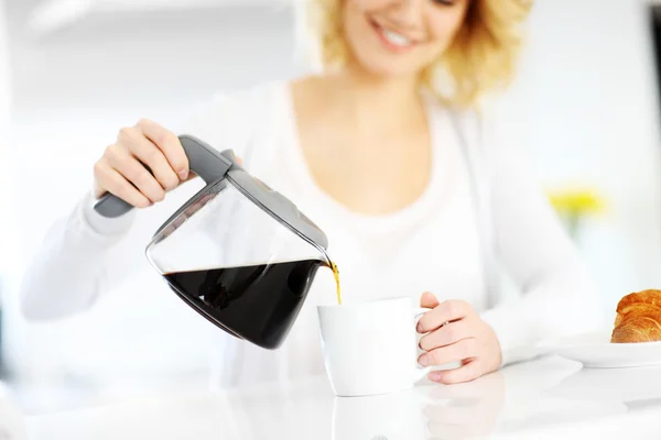 Junge Frau schenkt Kaffee ein — Stockfoto