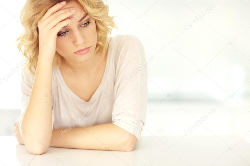 Young depressed woman at home