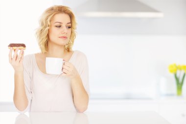 Genç kadın kahve ile donut yemek