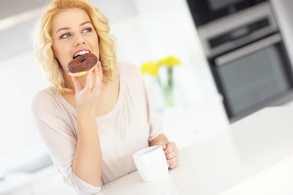 Junge Frau mit Donut und Kaffee — Stockfoto