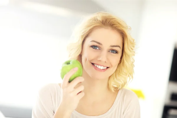 Mujer joven comiendo una manzana verde —  Fotos de Stock