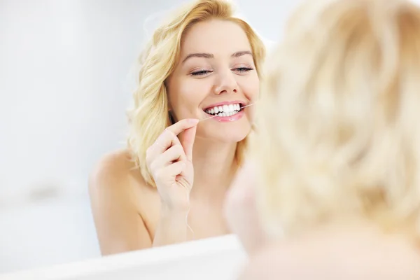 Mujer usando hilo dental —  Fotos de Stock