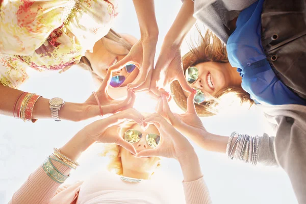 Mujeres amigas felices mostrando corazones — Foto de Stock