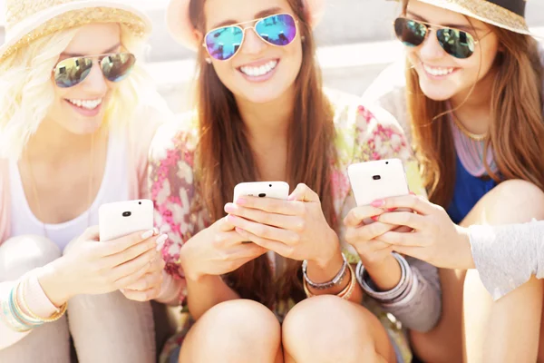 Grupo de amigos usando teléfonos inteligentes — Foto de Stock