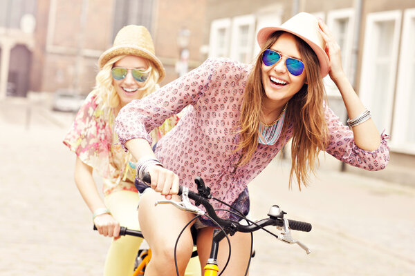 happy girls riding tandem bicycle