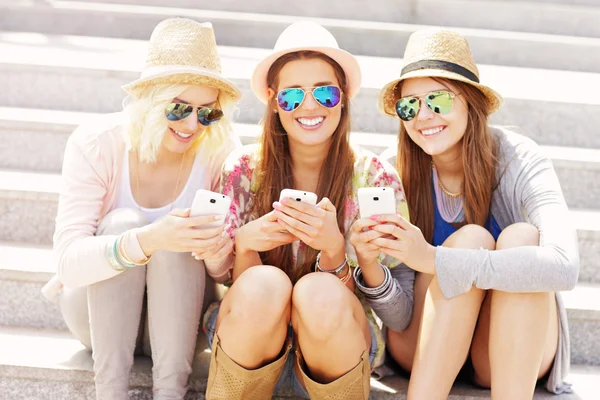 Grupo de amigos usando teléfonos inteligentes — Foto de Stock