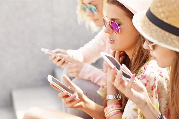 Vänner med smartphones i staden — Stockfoto