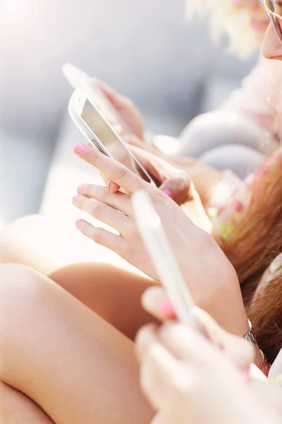 Groep van vrienden met behulp van smartphones — Stockfoto