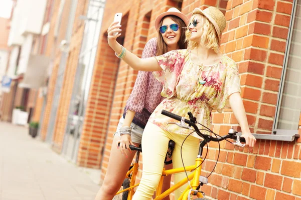 Girl friends riding tandem bicycle — Stock Photo, Image