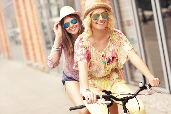 Happy girl friends riding bicycle — Stock Photo, Image