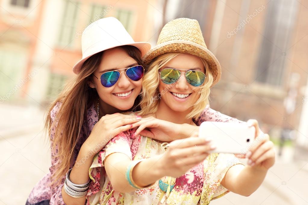 happy girl friends taking selfie