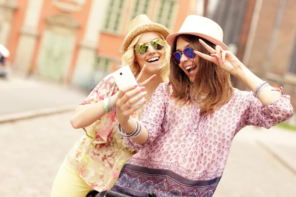 İki kız arkadaş smartphone kullanarak — Stok fotoğraf