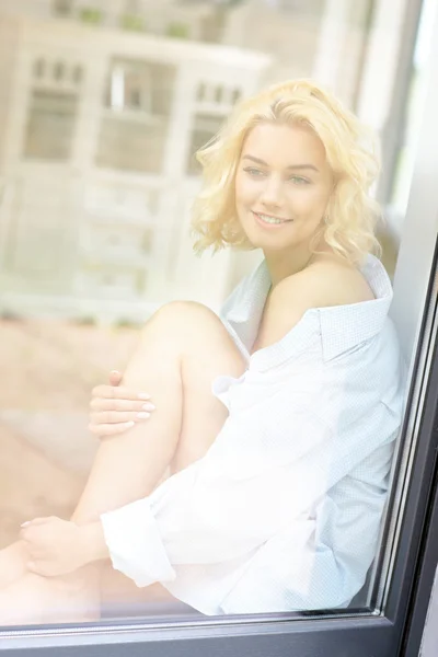 Giovane bella donna seduta alla finestra — Foto Stock