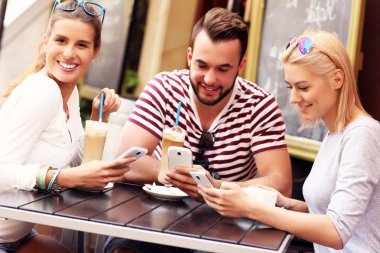 arkadaşlar akıllı telefonlar kullanarak bir kafede