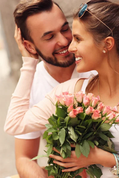花と若いロマンチックなカップル — ストック写真