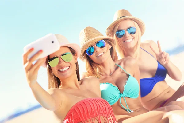 Gruppo di amici che scattano selfie sulla spiaggia — Foto Stock