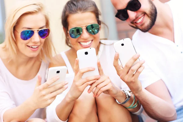 Skupina přátel pomocí chytré telefony — Stock fotografie