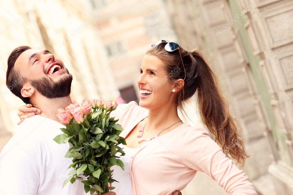 Joyful romantic couple with flowers