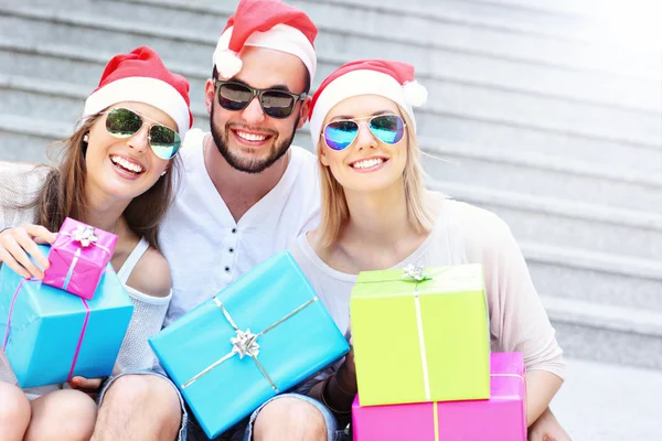 Sällskap i Santa hattar med presenterar — Stockfoto