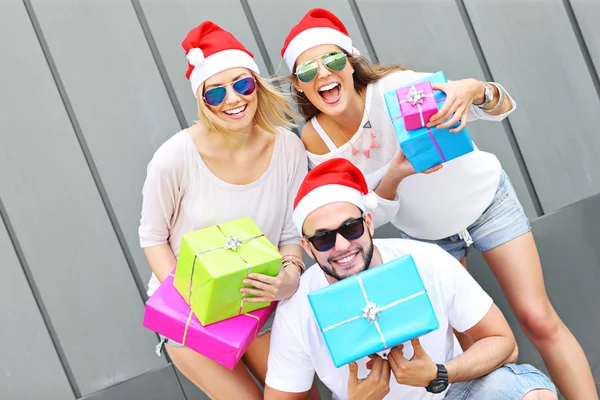 Grupo de amigos en los sombreros de Santa con regalos — Foto de Stock