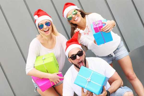 Grupo de amigos en los sombreros de Santa con regalos — Foto de Stock