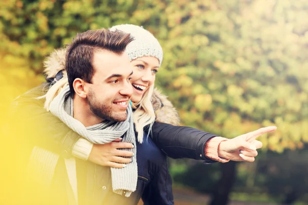 Young romantic couple pointing in the park — Stock Photo, Image