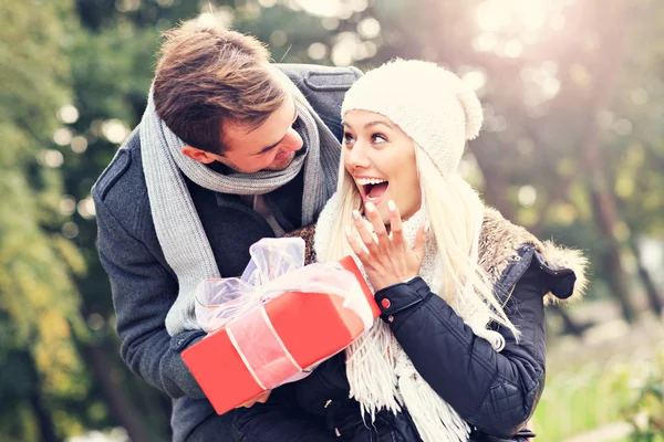 Young couple with a present in the park — Stock Photo, Image