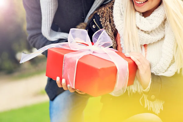 Coppia giovane con un regalo nel parco — Foto Stock