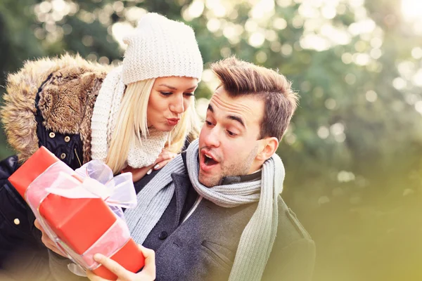 Young couple with a present in the park — Stock Photo, Image