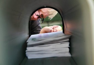Posta kutusuyla posta getiren ya da alan bir adam. Bir adam posta kutusundan birinci sınıf postalarını ve mektuplarını alır..  