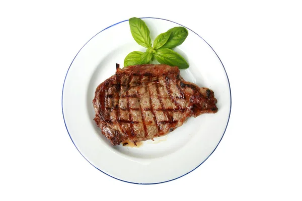 Steak Grilovaný Steak Bílém Talíři Zelenými Listy Bazalky Izolovaný Bílém — Stock fotografie