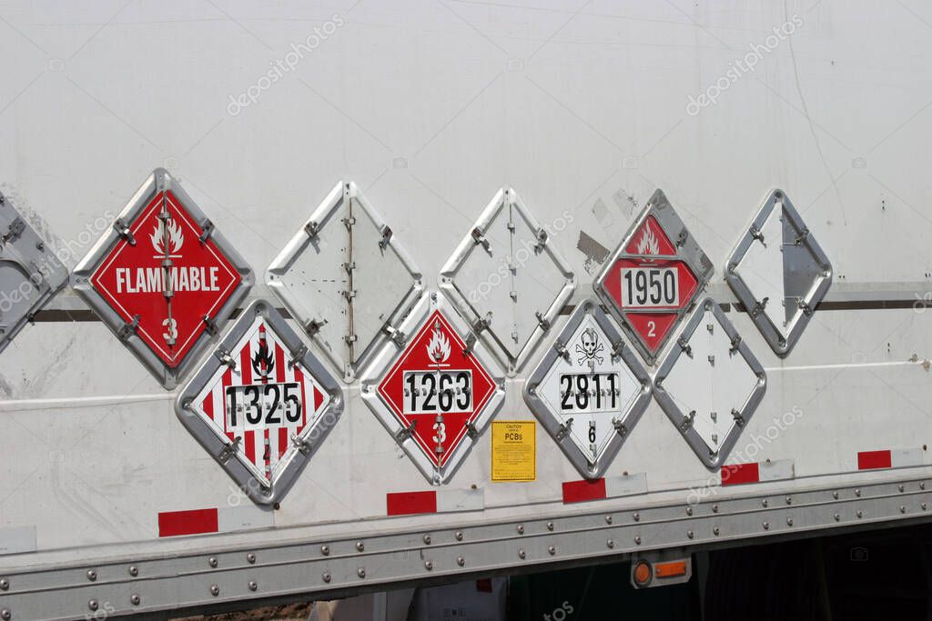 Various hazard plackards on the side of a truck.