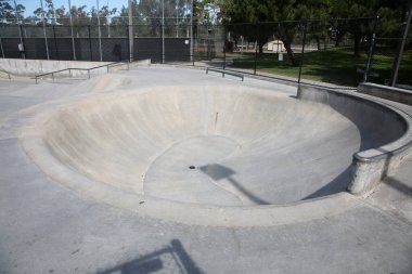California 'da rampaları ve boruları olan boş beton kaykay parkı manzarası. Kaykay parkları çocukların paten ve kaykay çalışmaları için harika bir yer. Her yaş için eğlencelidir. Kaykay Parkı Eğlencesi.