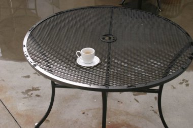 Kahve dükkanındaki masada seramik bir fincan kahve. Kahve fincanı, kafeteryada, ahşap masada. Klasik kahve kupası, İtalyan kapuçinosu. Lezzetli sabah içkisi. Kruvasanla latte. Kahvaltı içeceği..  