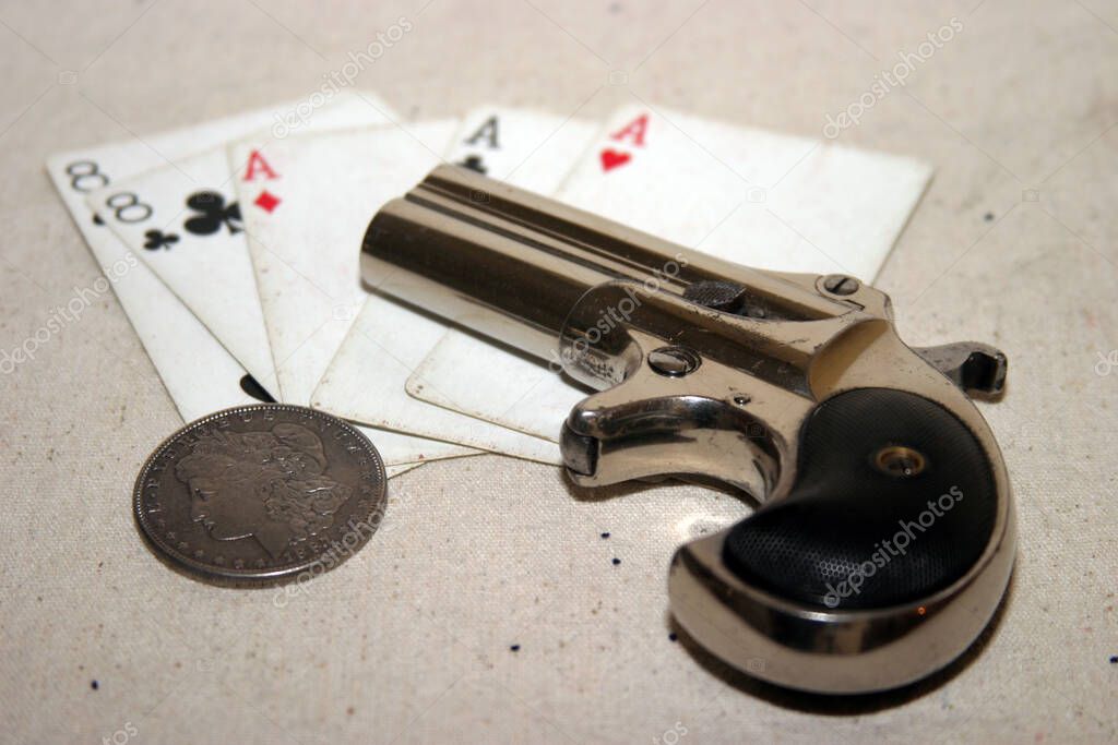 Genuine Antique 1887 Double Derringer Pocket Pistol. Isolated on white with room for your text or information. Circa 1889, Model 95, Type II Model 3 Double Derringer on card table with aces and eights aka a Dead Mans Hand. Dead Mans Hand. 