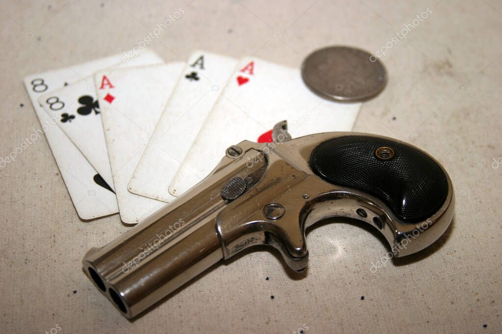 Genuine Antique 1887 Double Derringer Pocket Pistol. Isolated on white with room for your text or information. Circa 1889, Model 95, Type II Model 3 Double Derringer on card table with aces and eights aka a Dead Mans Hand. Dead Mans Hand. 