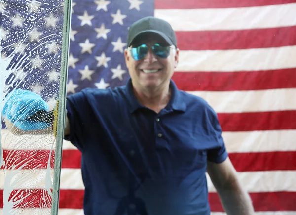 4th of July Window Washing. Window Cleaning. Window Washing. American flag background. Fourth Of July Patriotic Celebration. Cleaning windows for the Fourth of July Celebration.