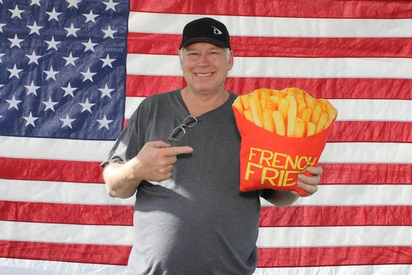 American Independence Day. Happy 4th of July. USA Independence Day. American flag. A happy Smiling American Man with an American Flag Background. Photo Booth portrait of a Proud American. Man in a 4th of July Photo Booth.