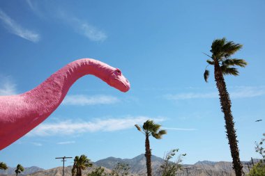 6 Haziran 2021 - Cabazon, California USA: Güneşli bir bahar gününde Pembe Brontosaurus Dinozor heykeli. Cabazon Dinozorları popüler bir yol kenarı cazibesidir. Kaliforniya 10. Otoyol 'dan Palm Springs' e doğru. 
