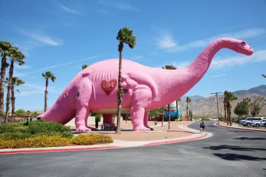 6 Haziran 2021 - Cabazon, California USA: Güneşli bir bahar gününde Pembe Brontosaurus Dinozor heykeli. Cabazon Dinozorları popüler bir yol kenarı cazibesidir. Kaliforniya 10. Otoyol 'dan Palm Springs' e doğru. 