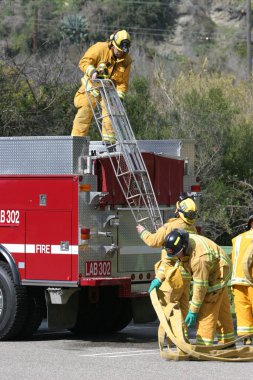 LAGUNA BEACH, CA - 19 Şubat 2009 'da Laguna Beach, Kaliforniya' da yerel itfaiye eğitim alanında yapılan yangın söndürme tatbikatlarında itfaiyeciler su püskürttü. İtfaiyeciler yangın teçhizatı eğitimi alıyor.. 